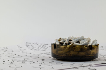 an ashtray filled with cigarette butts in close-up. a place to copy text.