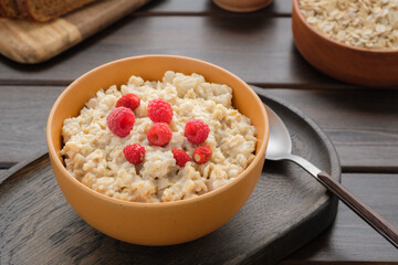 Oatmeal porridge with raspberries and strawberries in a bowl. Healthy eating concept. Vegan and vegetarian food.