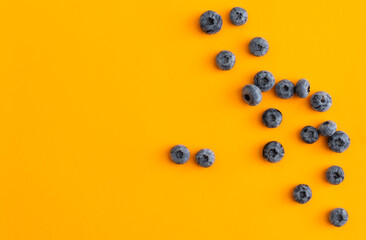 Colorful fruit pattern of blueberries on yellow background. Top view. Flat lay
