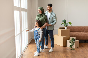 Happy muslim family looking at view from window