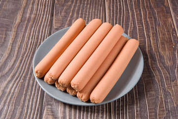 ham sausages in plate on wooden background.