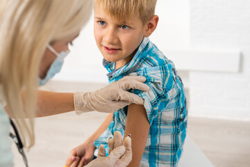 Young boy receiving vaccination immunisation by professional health worker
