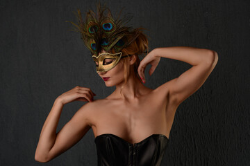 portrait of beautiful woman in black leather corset and venetian mask