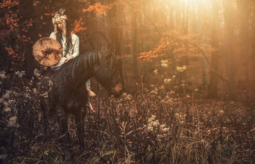 Shaman woman in autumn landscape with her horse.
