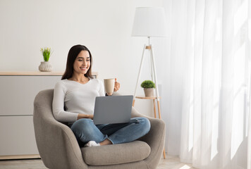 Young beautiful smiling casual woman enjoying cup of coffee