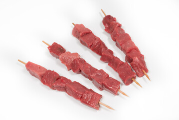 Four veal and beef skewers on a white background - obrazy, fototapety, plakaty