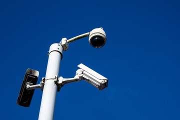 Outdoor security cameras on a metal pole against dark blue sky. Security industry. Government...