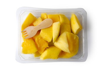 Fresh mango chunks and a small wooden ecology friendly fork in a plastic tray on white isolated background. Food supply industry. Exotic fruit product. Healthy food. Fruit snack for lunch.