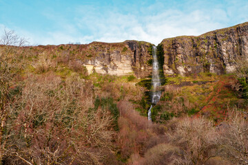 Stunning Devil's chimney waterfall in county Sligo, Ireland. Warm color tone, blue sky. Irish landscape. Popular tourist and travel landmark.
