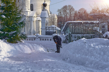 уборка снега лопатой. мужчина убирает снег на улице во дворе