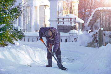уборка снега лопатой. мужчина убирает снег на улице во дворе