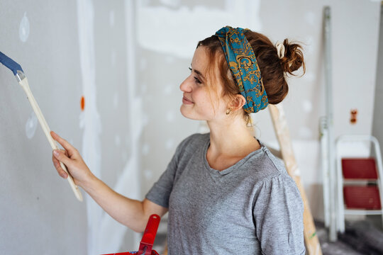 Young woman redecorating the walls of her house