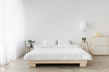 Fototapeta na wymiar Ideas for scandinavian minimalist bedroom. Double bed with pillows, soft white blanket, lamp and furniture