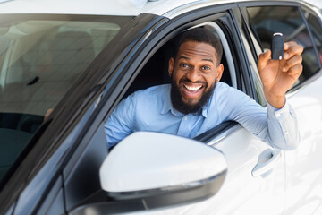 Happy Black Man Sitting In Car, Holding Key And Smiling At Camera