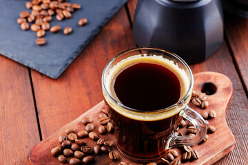 Coffee cup, geyser coffee maker and coffee beans on a wooden background. Ground coffee for making of coffee drinks. Copy space