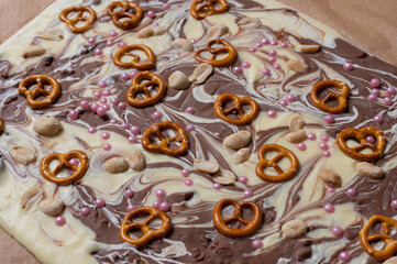 Weiße und braune Schokolade vorbereitet für eine Bruchschokolade dekoriert mit Brezel, Zucker...