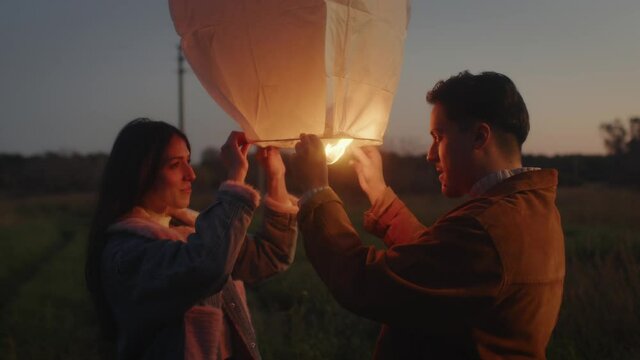 Coppia festeggia il nuovo anno con la lanterna cinese la notte in campagna