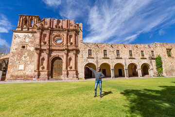 A young adult woman exhibits the facade of a very important museum in the city of Zacatecas in Mexico - obrazy, fototapety, plakaty