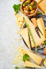 Parmesan cheese and snacks on a stone table. Top view. On a concrete background.