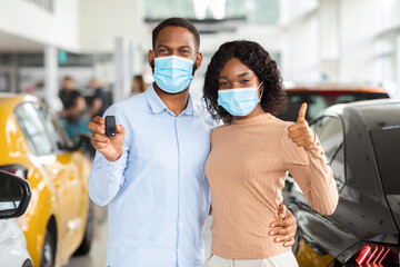 Fototapeta na wymiar Happy Black Couple In Masks Holding Car Key And Showing Thumb Up