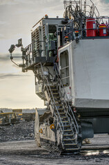 Big excavator in coal mine at cloudy day, low angle view