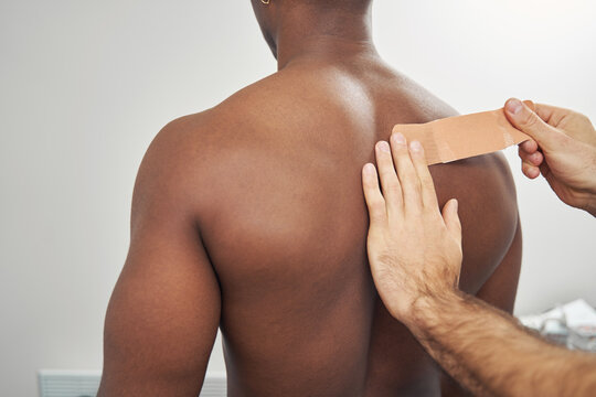 Professional physiatrist applying kinesiology taping technique for upper back pain