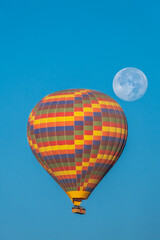 Colorful hot air balloon with the moon behind