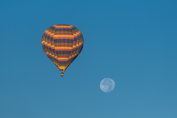 Colorful hot air balloon with the moon behind