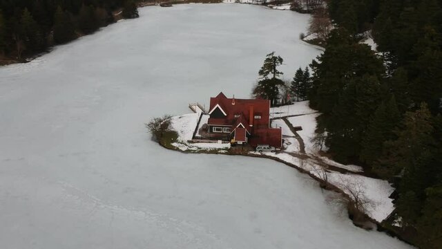 Bolu Golcuk National Park, lake wooden house on a snowy winter day in the forest in Turkey. Aerial drone view