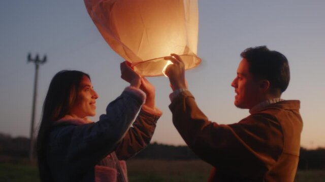 Coppia festeggia il nuovo anno con la lanterna cinese la notte in campagna