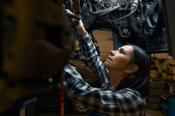 Fototapeta na wymiar Focused repair shop worker being absorberd in car diagnostics