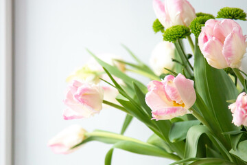 tender light rosy pink tulips bouquet on the window close up selective focus defocused