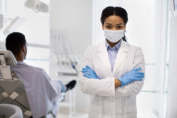 Portrait Of Young Black Female Stomatologist In Medical Mask Posing At Workplace