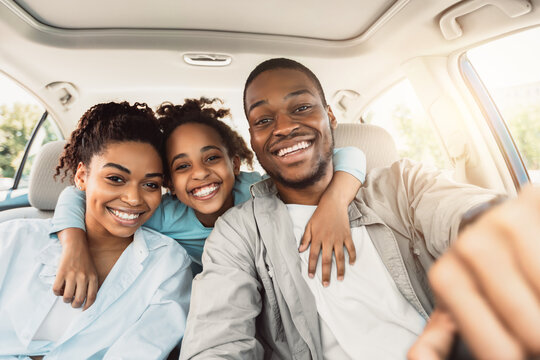 Joyful African American Family Hugging Sitting In Car During Trip