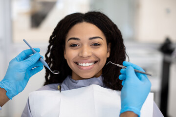 Portrait Of Smiling African American Lady Getting Teeth Treatment At Dental Clinic