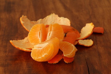 Peeled tangerine on a wood background. Mandarin contains beneficial elements and minerals. 
