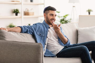 Fototapeta premium Jew guy using voice assistant on cellphone