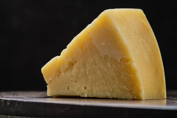 Closeup view of parmesan cheese on wooden cutting board