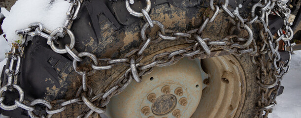 Unusual industrial background. Detail of a wheel with chains. Wheel of a tractor in the mountains...