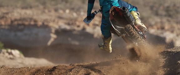 Racer boy on motorcycle participates in motocross race, active extreme sport, flying debris from a motocross in dirt track - obrazy, fototapety, plakaty