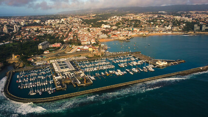 Obraz premium Aerial view of cascais portugal characteristics town view of the lighthouse and rocky cliff coastline with harbor and residential building for holiday season