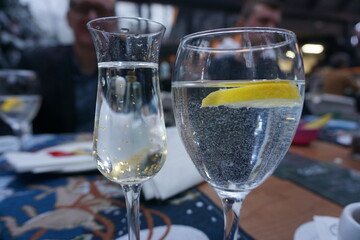 two glasses with golden raki and water