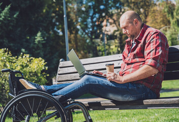 Obraz premium Freelancer with a physical disability who uses wheelchair working at the park