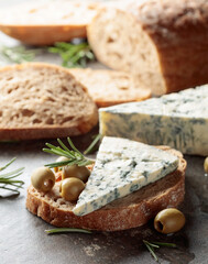 Blue cheese with green olives, rosemary, and bread.