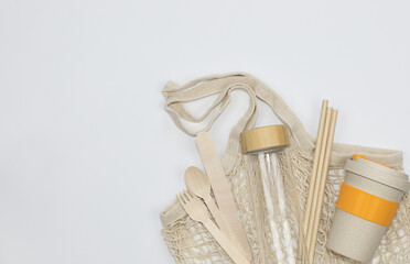 Reusable Cotton Mesh Bag with Glass Bottle, Bamboo Cup, Recycled Tableware. Zero waste, ecological concept. Flat lay,