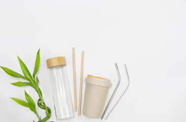Fototapeta na wymiar Reusable bamboo cup, glass bottle, stainless steel straws and paper.