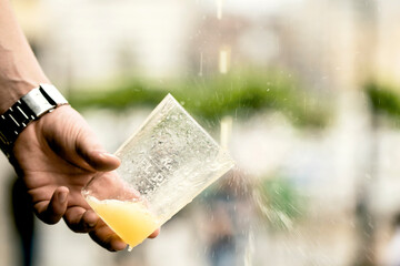 Man's hand pouring Asturian, Spanish apple cider into a glass. Cider is an alcoholic beverage made...