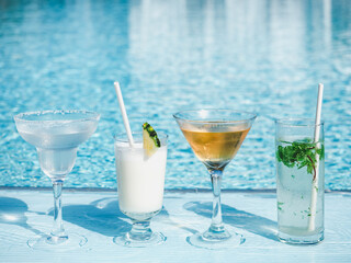 Beautiful glasses with a refresh cocktail on the background of the swim pool. Top view, close-up, outdoors . Vacation and travel concept. Moments of celebration