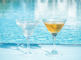 Beautiful glasses with a refresh cocktail on the background of the swim pool. Top view, close-up, outdoors . Vacation and travel concept. Moments of celebration