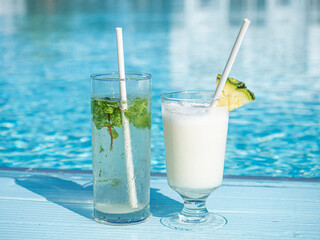 Beautiful glasses with a refresh cocktail on the background of the swim pool. Top view, close-up, outdoors . Vacation and travel concept. Moments of celebration